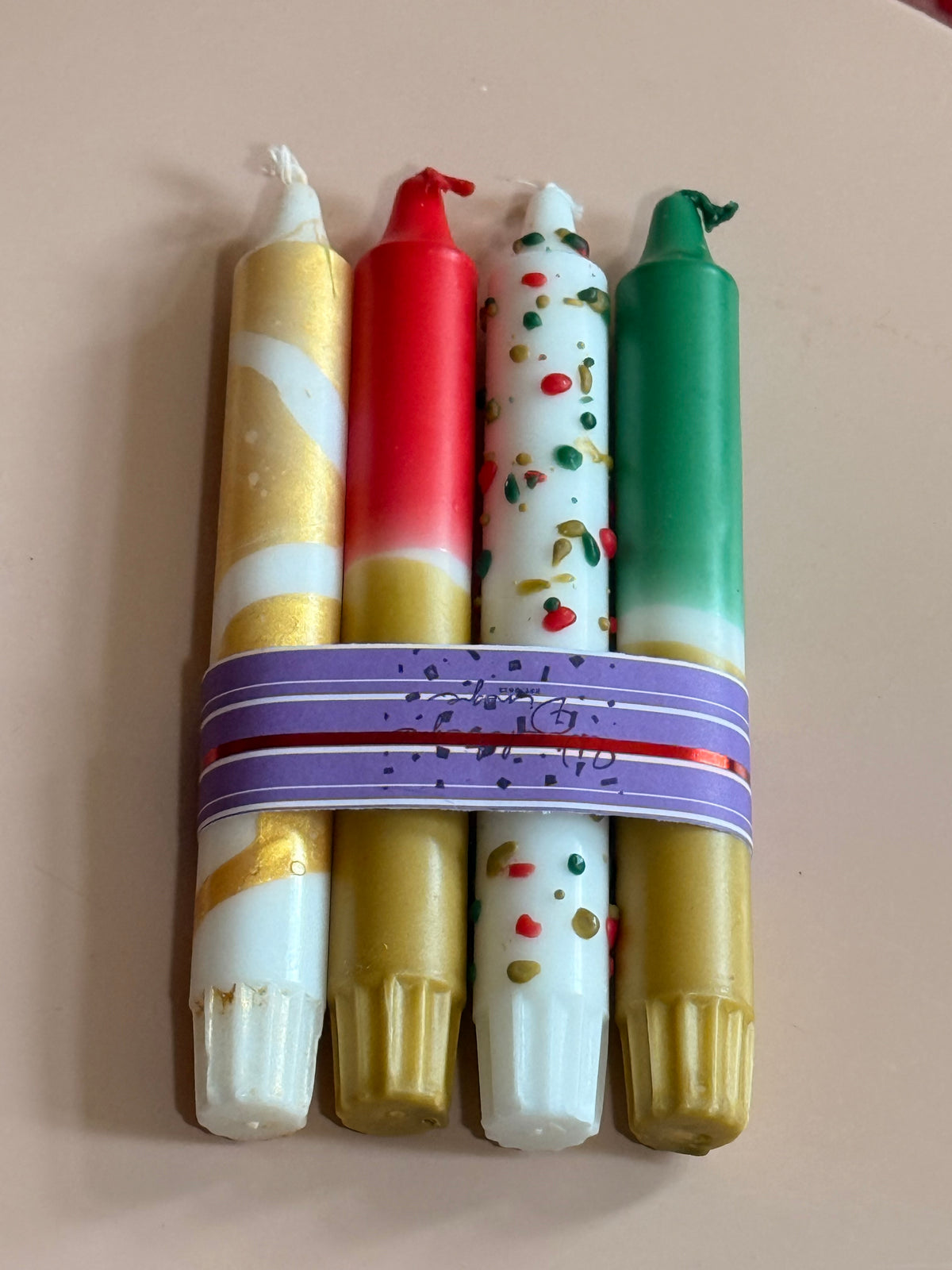 Vier weihnachtliche Dip Dye Stabkerzen in Rot, Grün, Gold und Weiß mit Banderole