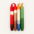 Dip Dye Kerzen 4er Set Weihnachtszeit von WichtigeDinge – vier handgefärbte Stabkerzen in Rot, Braun, Orange, Blau und Grün auf warmweißem Hintergrund