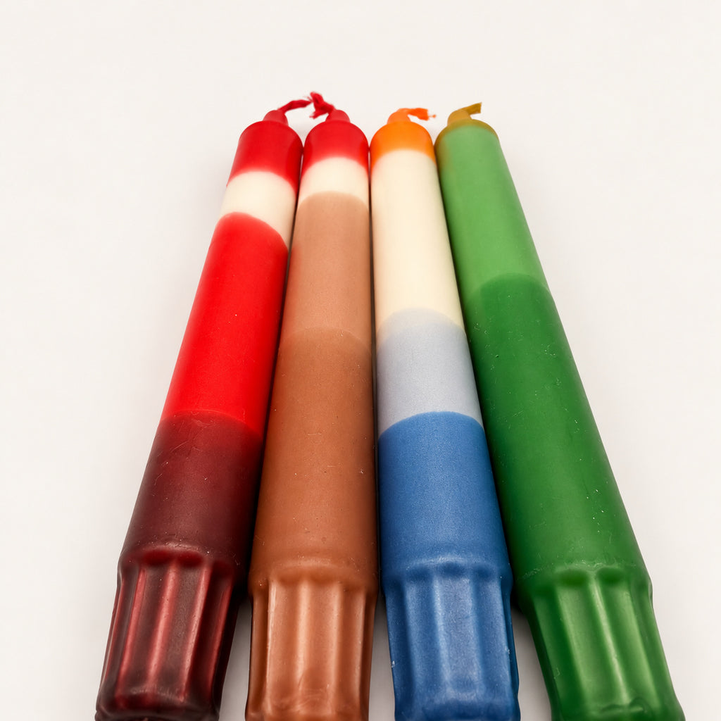 Weihnachtszeit – vier handgefärbte Dip Dye Kerzen aus niedriger Perspektive mit Blick vom Kerzenfuß auf die farbigen Spitzen
