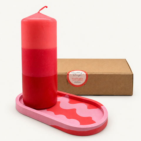Geschenkset Pink Crush: Dip-Dye-Stumpenkerze Raspberry Blush auf rosa Wellen-Ablage vor der Geschenkbox