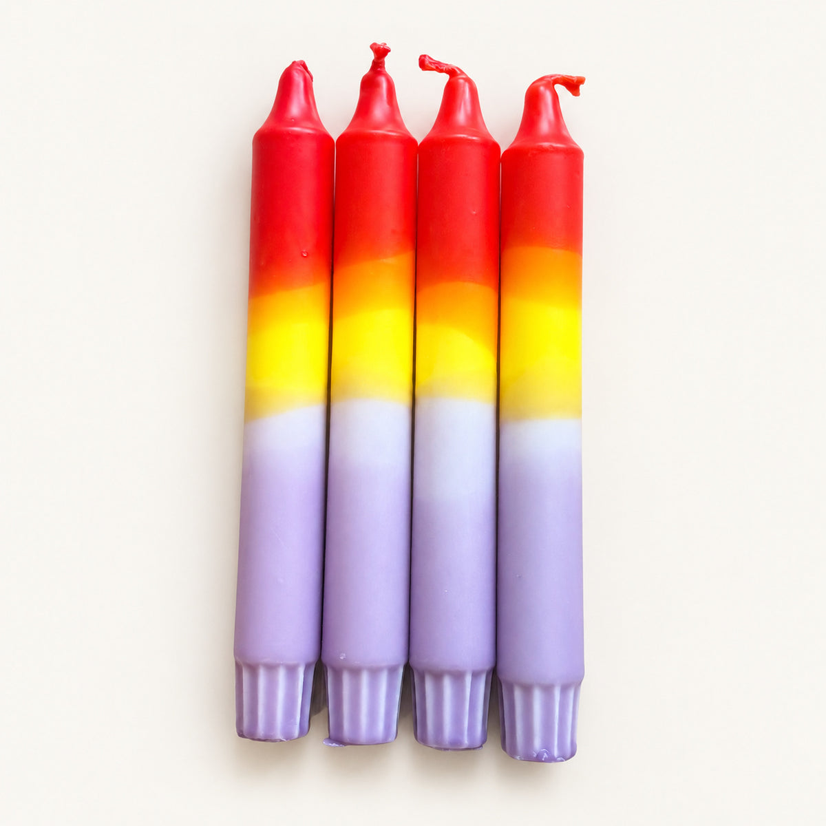 Candy Sundown – vier handgefärbte Dip Dye Kerzen, freigestellt auf schlichtem warmweißem Hintergrund