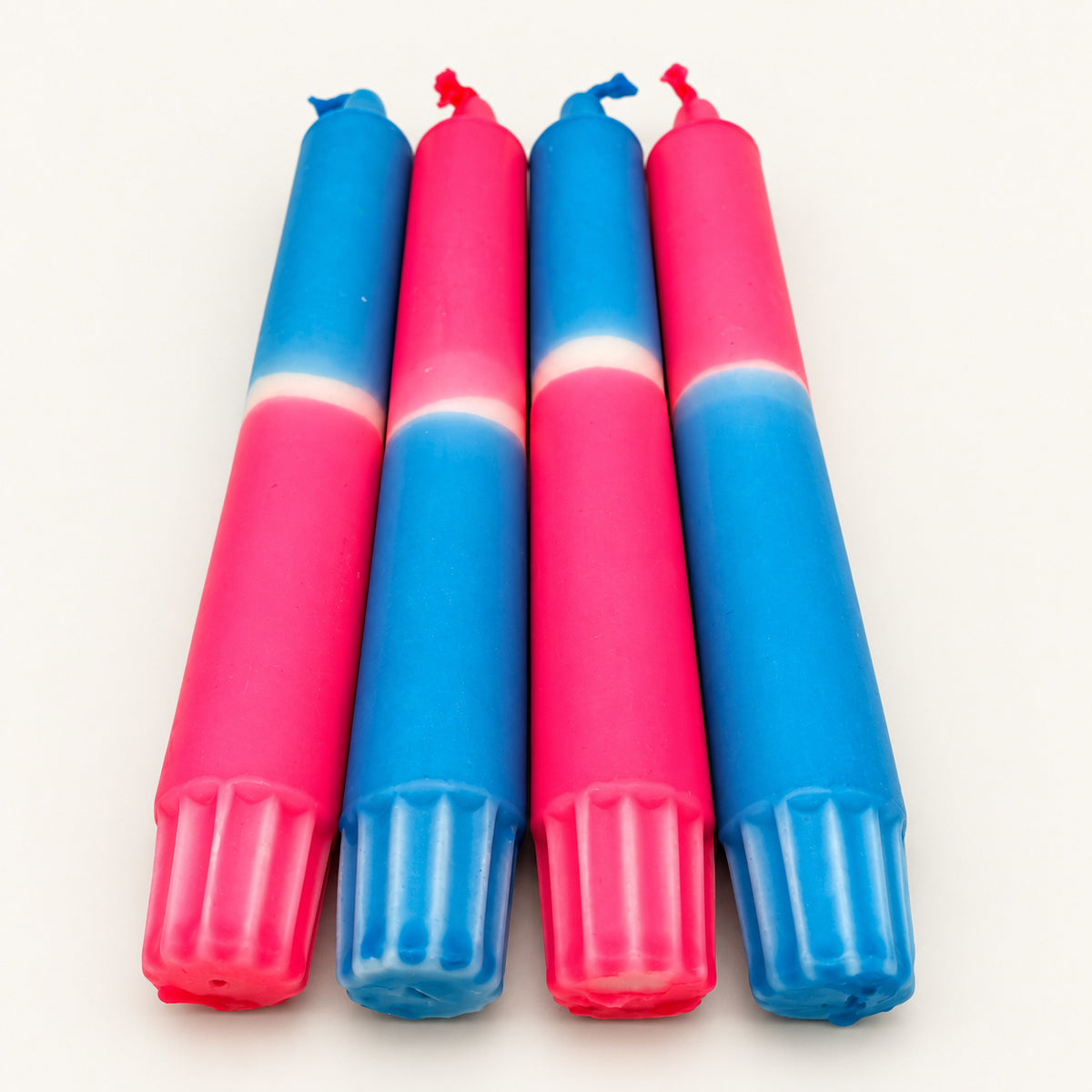 Neon Dream – Blick vom Kerzenfuß auf die Farbverläufe auf neutralem warmweißem Hintergrund