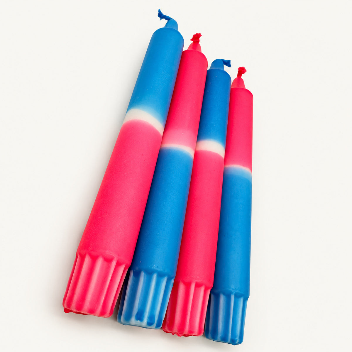 Neon Dream – Detailaufnahme der handgefärbten Kerzen auf neutralem warmweißem Hintergrund